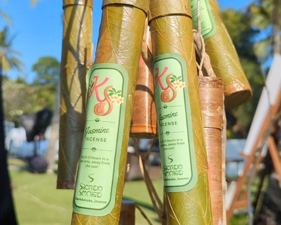 Custom branded incense tubes held up outdoors in Bali