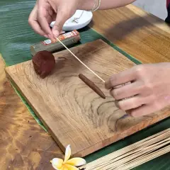 Shaping incense dough around a bamboo stick