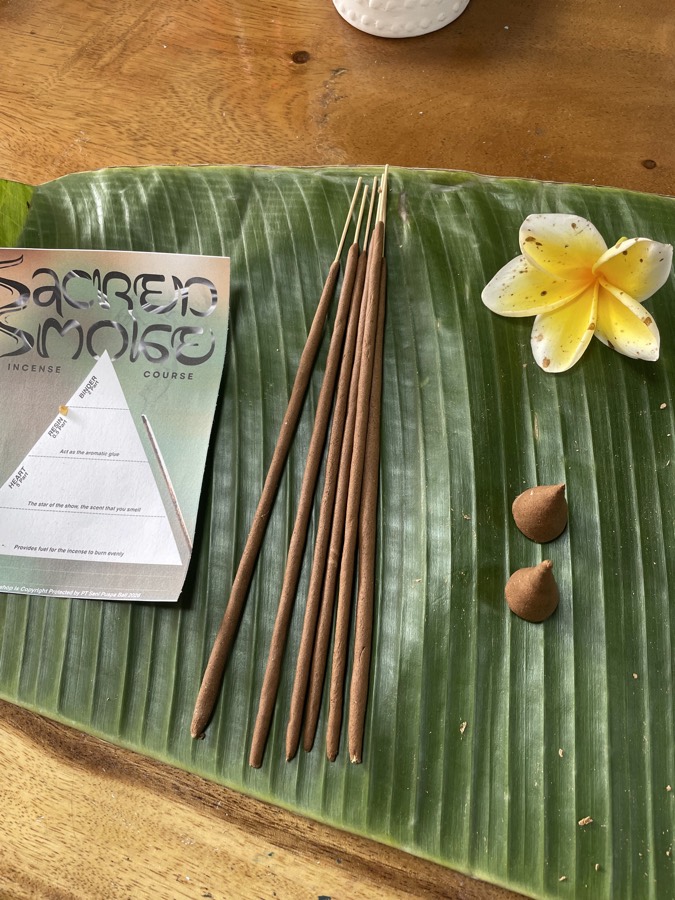 Incense formula sheet beside handmade sticks on a banana leaf