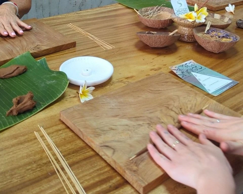 Hands palm rolling incense dough on a wooden board