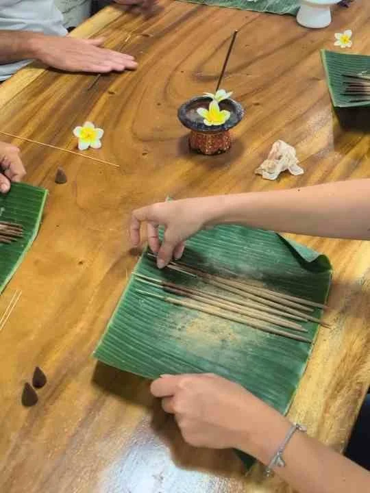 Hands preparing incense materials on a wooden table